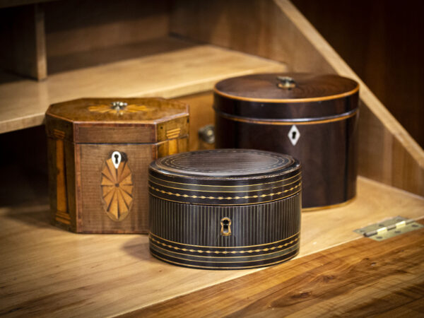 Tea caddy within a decorative setting amongst other tea caddies.