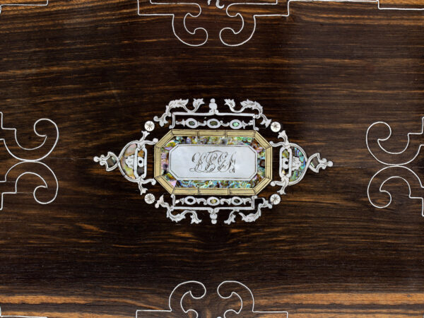 Close up of the intricate mother of pearl and abalone initial plaque