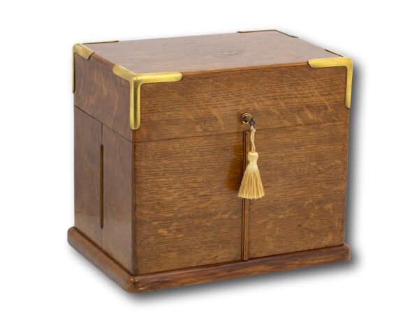 With Brass Tray From our Decanter collection, we are delighted to offer this Victorian Oak Decanter Box. The Decanter Box of rectangular form made from oak with brass stood upon a stepped plinth base with corner mounts and a circular brass escutcheon. The Decanter Box opens by firstly lifting the lid which reveals four tightly fitted classes with brass mounts, then opening the two hinged doors to reveal the four decanter bottles with faceted stoppers and diamond quilt pattern, four further glasses and a gilded brass serving tray which sits neatly upon a purple velvet lined shelf built into the base of the box. The Box dates to the late 19th century during the Victorian period circa 1880. The Decanter Box comes complete with a working lock and tasselled key. Victorian, an era of British History corresponding approximately with the reign of Queen Victoria from the 20th of June 1837 until her death on 22 January 1901 however, there are arguments stating that the Victorian era is actually from 1820 until 1914 proceeded by Georgian era and followed by the Edwardian era. Oak has many global variations. European Oak, also known as English or French Oak, is found in Europe. It is a well known and very popular wood due to its different types and strength yielding many uses. It can have a very simple clean look or a highly figured finish varying from tree to tree. European Oak can be Golden-yellow to light-brown in colour. Brown Oak is from the United Kingdom and its name is derived from its red-brown colour which is resulted from an attack by “beef-steak” fungus. This usually gives the wood an even colour, however, sometimes the wood can be streaked with a light brown giving it the name Tiger Oak. With every purchase from Mark Goodger Antiques, you will receive our latest catalogue, a Certificate of Authenticity, detailed care instructions for your chosen piece and an independent invoice (for insurance purposes) will be enclosed. As well as being protected by a no-hassle, money-back policy, your piece will be entirely insured during the shipping process to ensure the safety of your item.
