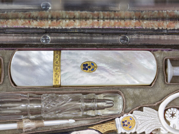 Close up of the mother of pearl needle case with gold mounts and pansy decoration