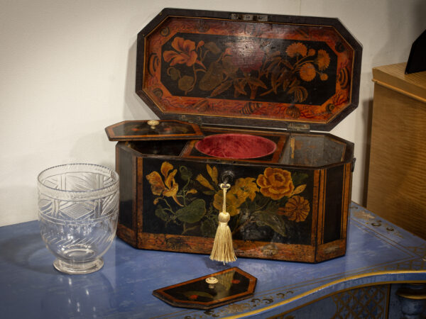 Overview of the painted tea caddy in a decorative collectors setting