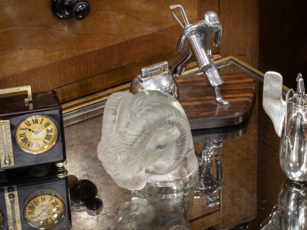 Rene Lalique Rams Head Car Mascot in a decorative collectors setting.