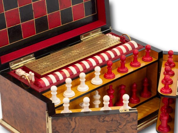 Close up of the top of the box showing the chess pieces, draughts counters and the cribbage board