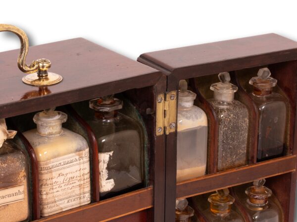 Close up of the poison compartment latch in the centre of the Mahogany Apothecary Cabinet with Poison Compartment