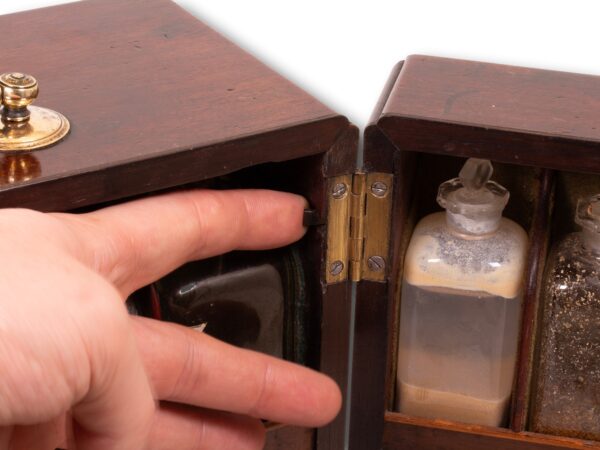 Close up of the poison compartment latch in the centre of the Mahogany Apothecary Cabinet with Poison Compartment